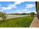 Lush backyard featuring a lake view, verdant lawn, and brick-paved patio at 4337 Summer Breeze Way, Kissimmee, FL 34744