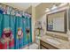Bathroom features a single sink vanity with a granite counter and colorful shower curtain at 4337 Summer Breeze Way, Kissimmee, FL 34744