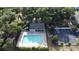 Aerial shot of community pool with lounge chairs, surrounded by lush greenery and a parking area at 4337 Summer Breeze Way, Kissimmee, FL 34744