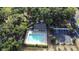 Aerial shot of community pool with lounge chairs, surrounded by lush greenery and a parking area at 4337 Summer Breeze Way, Kissimmee, FL 34744