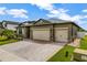 Charming one-story home featuring a three-car garage, decorative stone accents, and a brick paved driveway at 4337 Summer Breeze Way, Kissimmee, FL 34744