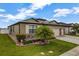 Well-maintained one-story home with a lush landscaped lawn featuring a palm tree and stone accents at 4337 Summer Breeze Way, Kissimmee, FL 34744
