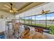 Screened patio with ceiling fans, rocking chairs, and an outdoor dining table and chairs at 4337 Summer Breeze Way, Kissimmee, FL 34744