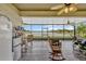 Screened patio with ceiling fans, and rocking chairs overlooks a lake and white fence at 4337 Summer Breeze Way, Kissimmee, FL 34744