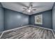 Neutral bedroom with wood-look floors, ceiling fan, and a window providing natural light at 525 Georgetown Dr # D, Casselberry, FL 32707