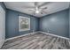 Spare bedroom with wood-look floors, ceiling fan, and a window providing natural light at 525 Georgetown Dr # D, Casselberry, FL 32707