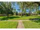 Inviting front lawn with lush green grass and mature trees, offering a serene and picturesque view of the complex at 525 Georgetown Dr # D, Casselberry, FL 32707