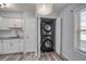 Convenient laundry closet with stacked washer and dryer, white cabinets, and neutral countertops at 525 Georgetown Dr # D, Casselberry, FL 32707