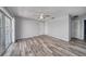 Spacious living room with wood-look floors, ceiling fan, sliding doors to the outside, and neutral paint at 525 Georgetown Dr # D, Casselberry, FL 32707