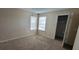 Bedroom with neutral carpet, two windows and an open door to closet at 5501 Rosebriar Way # 111, Orlando, FL 32822
