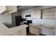 Bright kitchen boasts black appliances, white countertops and cabinetry and stainless sink at 5501 Rosebriar Way # 111, Orlando, FL 32822
