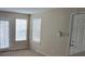 Living room with tan carpet and walls, and a sliding glass door to the outside at 5501 Rosebriar Way # 111, Orlando, FL 32822