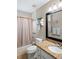 Bathroom with granite counter, modern sink, mirror, and tiled tub with shower at 5512 Hamlin Close, Davenport, FL 33896
