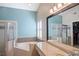 Bright bathroom with tub, granite counters, shower and shuttered window at 5512 Hamlin Close, Davenport, FL 33896