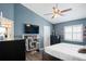 Cozy bedroom with blue walls, ceiling fan, shuttered windows, and TV on display at 5512 Hamlin Close, Davenport, FL 33896