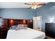 Comfortable bedroom with headboard, ceiling fan, adjacent bathroom, and dark furnishings at 5512 Hamlin Close, Davenport, FL 33896
