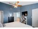 Inviting bedroom with ensuite bathroom, blue walls, ceiling fan and modern furnishings at 5512 Hamlin Close, Davenport, FL 33896