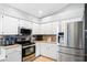 Well-lit kitchen featuring granite countertops, stainless steel appliances and white cabinetry at 5512 Hamlin Close, Davenport, FL 33896