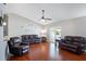 Spacious living room featuring hardwood floors, vaulted ceilings and three leather sofas at 5512 Hamlin Close, Davenport, FL 33896