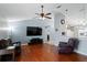 Cozy living room featuring hardwood floors, ceiling fan and large television at 5512 Hamlin Close, Davenport, FL 33896