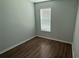 A bright bedroom with neutral walls, a window for natural light, and wood-style floors at 5624 Beggs Rd, St Cloud, FL 34771