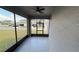Outdoor lanai with tiled flooring, screened walls with street view and ceiling fan at 5624 Beggs Rd, St Cloud, FL 34771