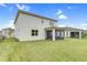 View of the back exterior of the home and the screened-in patio, with a beautiful lawn at 6413 Clover St, Lake Hamilton, FL 33851
