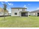 View of the home's backyard with a screened-in patio and a large lawn, perfect for outdoor activities at 6413 Clover St, Lake Hamilton, FL 33851