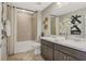This bathroom features a dual sink vanity with dark cabinets and a shower with tile surround at 6413 Clover St, Lake Hamilton, FL 33851