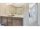 Bathroom featuring double sinks with gray cabinets, a large mirror, and a view to the bedroom at 6413 Clover St, Lake Hamilton, FL 33851