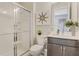 This bright bathroom has a tiled shower, a sink with dark wood cabinet, and minimalist decor at 6413 Clover St, Lake Hamilton, FL 33851