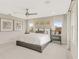 This neutral bedroom features large windows, contemporary artwork, and a modern ceiling fan at 6413 Clover St, Lake Hamilton, FL 33851