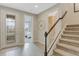 Inviting foyer with decorative glass door, ceramic tile flooring, and carpeted staircase leading upstairs at 6413 Clover St, Lake Hamilton, FL 33851