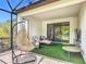 This modern patio has a swing chair, cushioned lounge, side tables, and turf flooring, perfect for outdoor relaxation at 684 San Augusto Dr, Poinciana, FL 34759