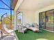 This screened patio has a swing chair, cushioned lounge, side tables and turf flooring creating a cozy outdoor retreat at 684 San Augusto Dr, Poinciana, FL 34759