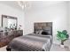 Cozy bedroom featuring a stylish bed with a striped comforter, modern light fixture, and a wooden dresser at 684 San Augusto Dr, Poinciana, FL 34759