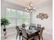 Dining room features a contemporary chandelier, stylish decor, and large windows with bright natural light at 684 San Augusto Dr, Poinciana, FL 34759