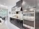 A modern kitchen features sleek dark cabinets, stainless steel appliances, and white countertops at 684 San Augusto Dr, Poinciana, FL 34759