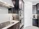Modern kitchen featuring dark cabinets, white subway tile backsplash, and stainless steel appliances at 684 San Augusto Dr, Poinciana, FL 34759