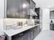 Modern kitchen boasts dark cabinetry, stainless steel appliances, and stylish white countertops at 684 San Augusto Dr, Poinciana, FL 34759