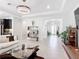 Bright living room with modern furnishings, sleek lighting, and a seamless connection to the foyer and kitchen at 684 San Augusto Dr, Poinciana, FL 34759