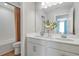 Bright bathroom featuring a double vanity, large mirror, and a bathtub with shower at 725 Lake Dell Rd, Dundee, FL 33838
