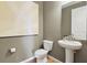 Stylish powder room features a pedestal sink, decorative mirror, and neutral wall paint at 725 Lake Dell Rd, Dundee, FL 33838