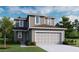 Charming two-story home features a symmetrical facade, neutral color palette, and attached two-car garage at 725 Lake Dell Rd, Dundee, FL 33838