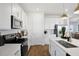 Well-equipped kitchen with stainless steel appliances, white cabinets, and a large island with sink at 725 Lake Dell Rd, Dundee, FL 33838