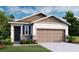 Charming single-story home featuring stone accents, a two-car garage, and lush green landscaping at 730 Lake Dell Rd, Dundee, FL 33838