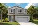 Charming two-story home featuring gray siding, a two-car garage, and a lush green lawn at 733 Lake Dell Rd, Dundee, FL 33838