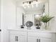 Stylish bathroom featuring double sinks, white countertops, and a large mirror with decorative lighting at 737 Lake Dell Rd, Dundee, FL 33838