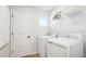 Clean laundry room with new white washer and dryer, storage shelf and a door at 737 Lake Dell Rd, Dundee, FL 33838