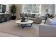 Cozy living room featuring neutral tones, comfortable sofas, a round coffee table, and large windows with curtains at 737 Lake Dell Rd, Dundee, FL 33838